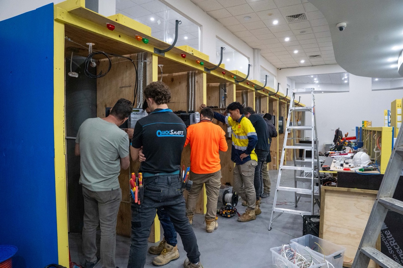 Electrical students completing hands-on wiring and fault-finding in a simulated electrical training environment