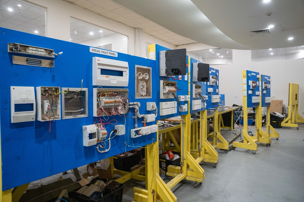 Electrical apprentices installing wiring and components as part of practical training